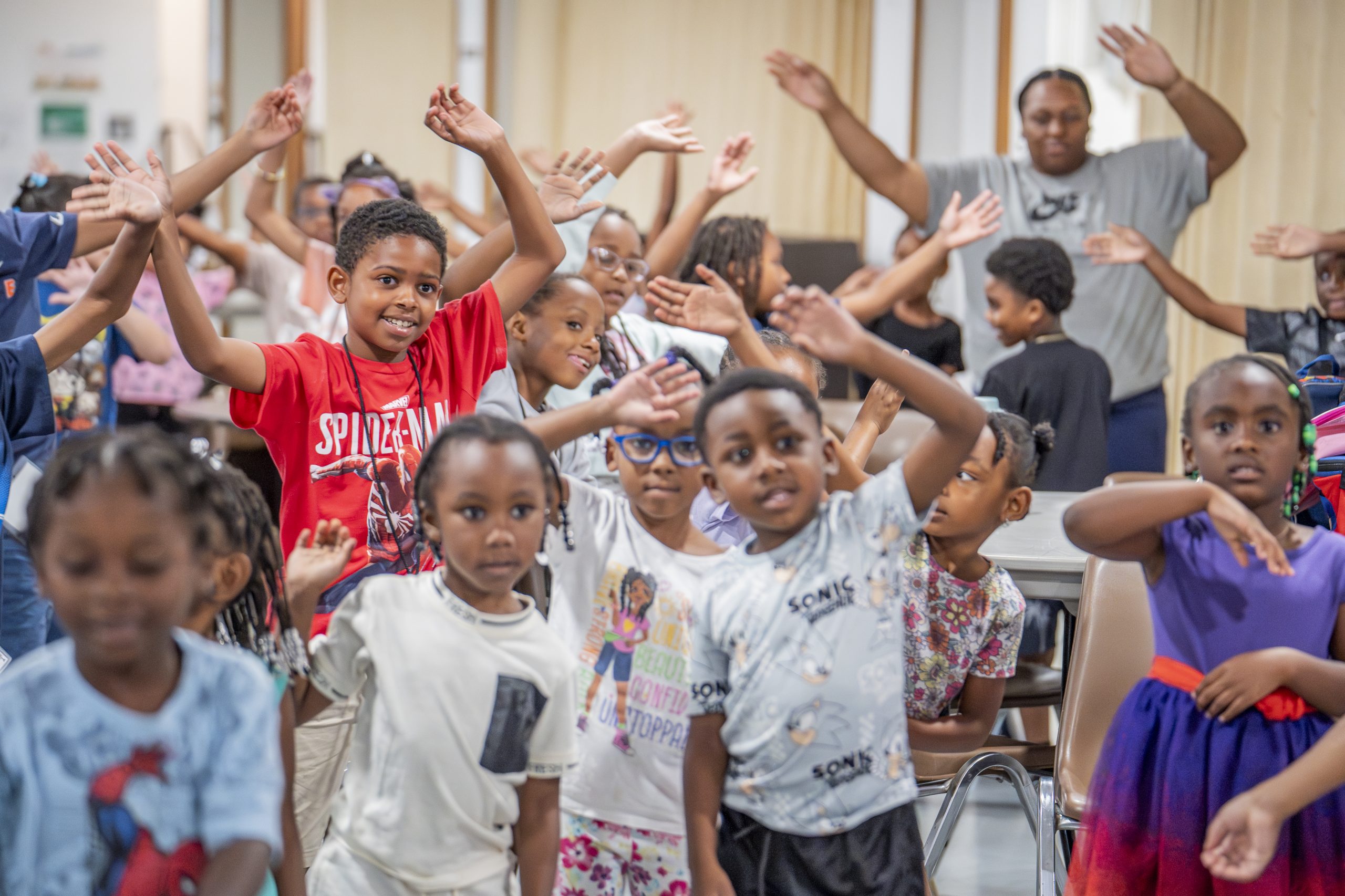 A group of children raising their hands